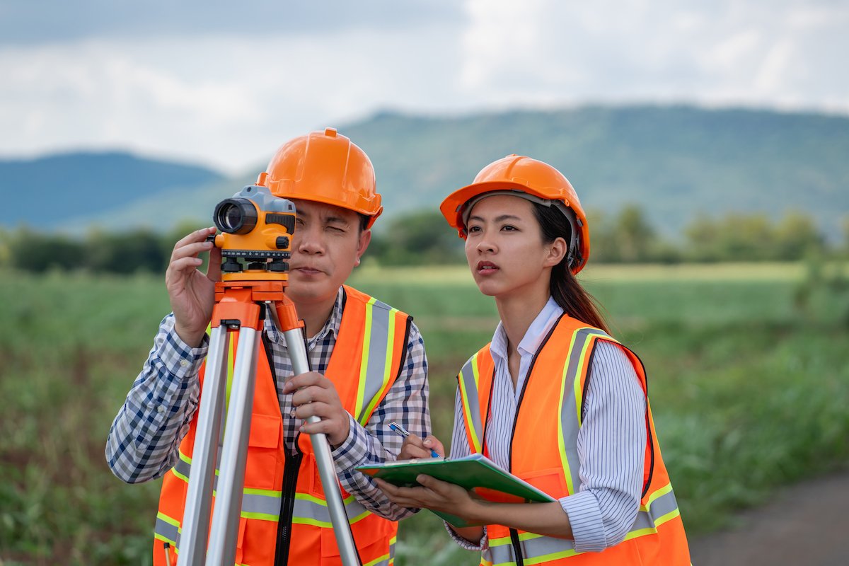Survey team is working with a theodolite and road construction plans Civil engineers are taking measurements with surveying tools during the construction Lao Value Property Valuation
