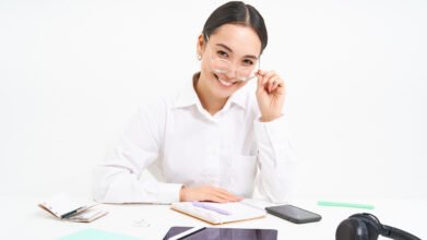 Portrait of successful businesswoman office manager at workplace sits with digital tablet and her working documents wears glasses smiles at camera Lao Value Property Valuation