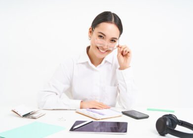 Portrait of successful businesswoman office manager at workplace sits with digital tablet and her working documents wears glasses smiles at camera Lao Value Property Valuation